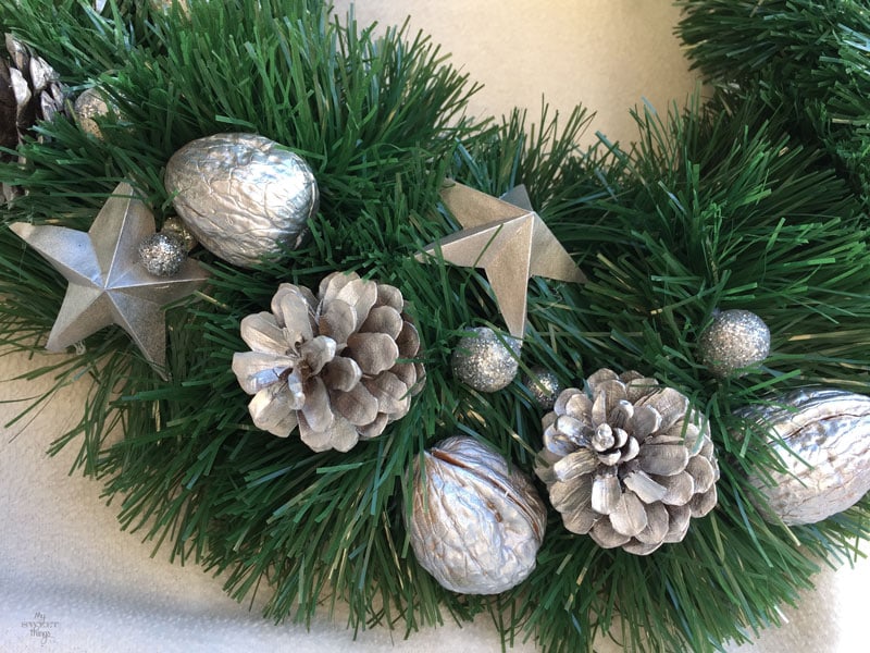 Cómo hacer una corona de Navidad casera fácil y elegante, usando cartón, piñas, nueces y una guirnalda | Via www.sweethings.net 