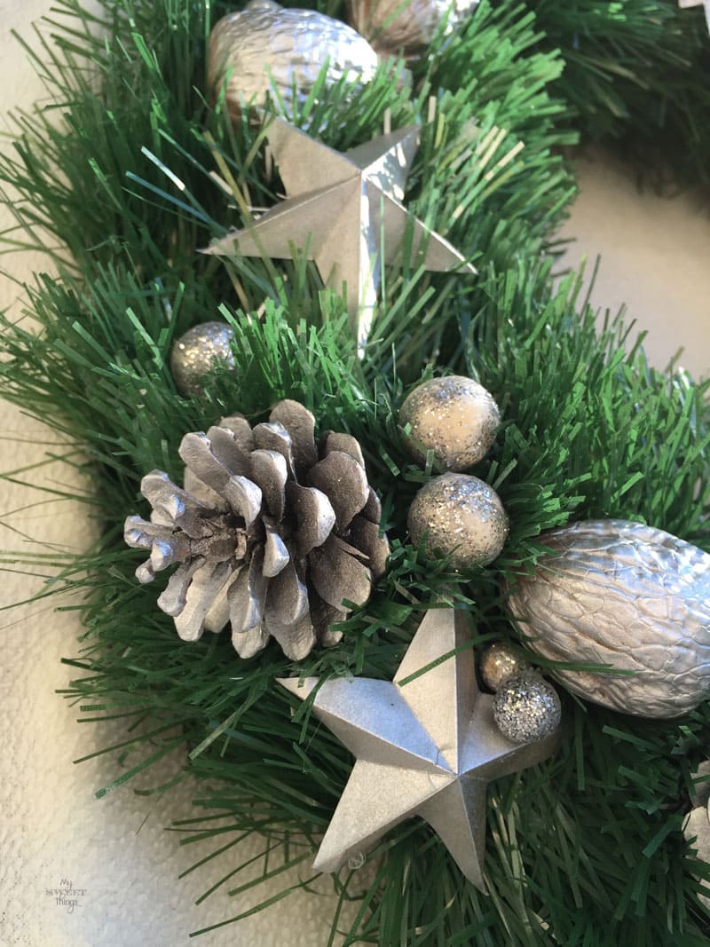 Cómo hacer una corona de Navidad casera fácil y elegante, usando cartón, piñas, nueces y una guirnalda | Via www.sweethings.net 