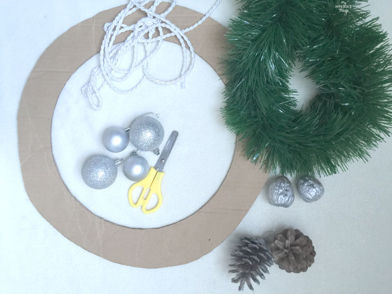 How to make an easy and chic DIY Christmas wreath, using cardboard, pine cones, nuts and a tinsel | Via www.sweethings.net 