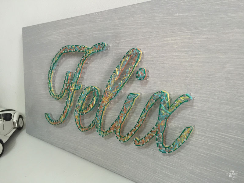 How to make an cool string wall art as a DIY birthday gift using a piece of scrap wood, some yarn and head nails