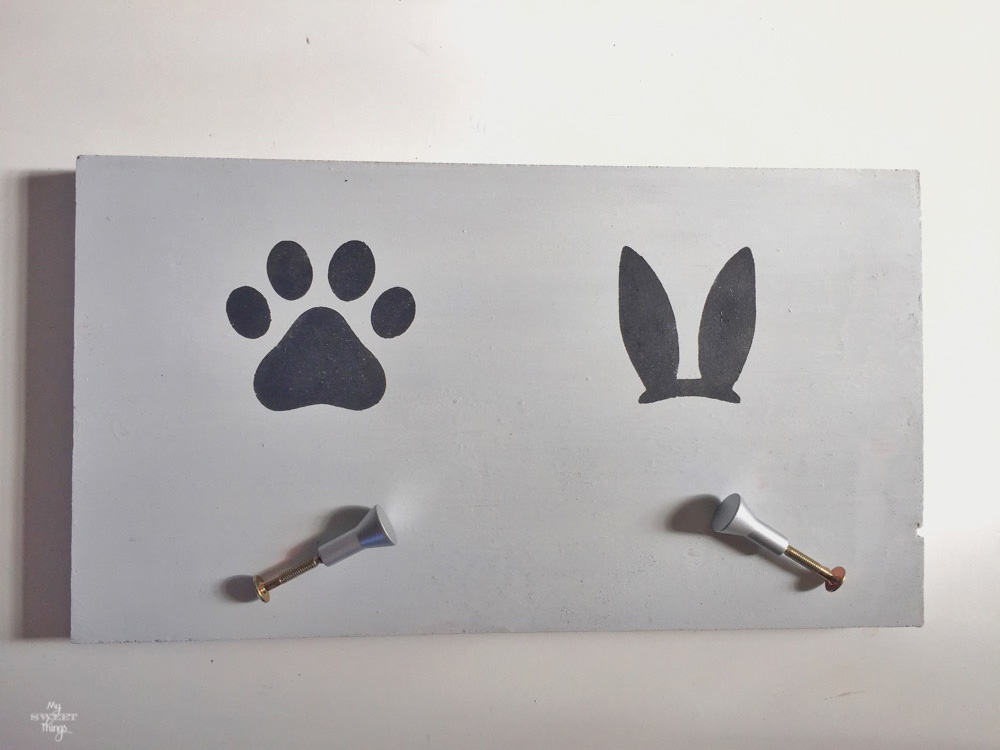 DIY dog and bunny leash holder - A piece of scrap wood, paint, stencils and knobs · Via www.sweethings.net