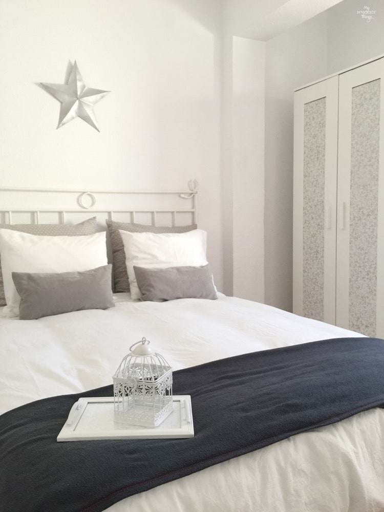 How to get a bright look in your bedroom on a budget, add little details such a cage or a small tray, coordinated pillows and a metal star · Via www.sweethings.net