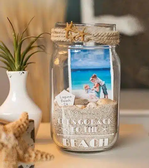 Recuerdos de vacaciones reciclando un frasco de cristal y arena de la playa junto con fotografias